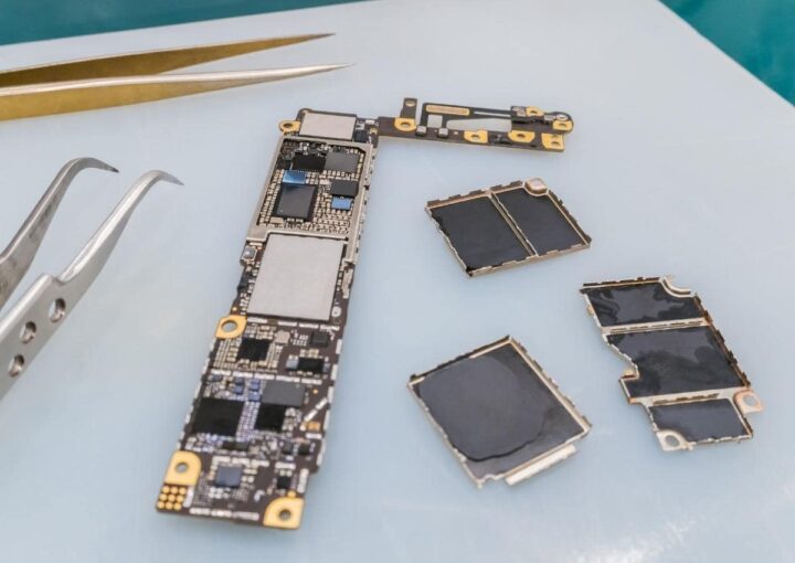 A cell phone undergoing repair with precision tools