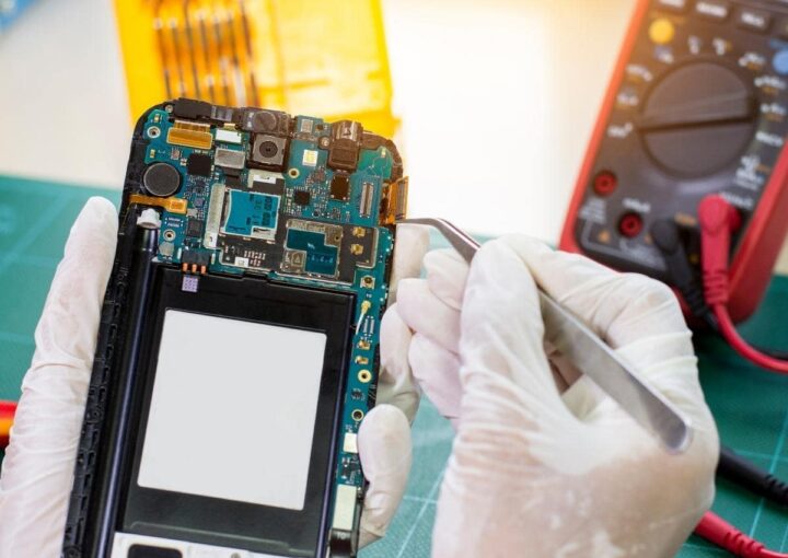 a person in white gloves holding a cell phone