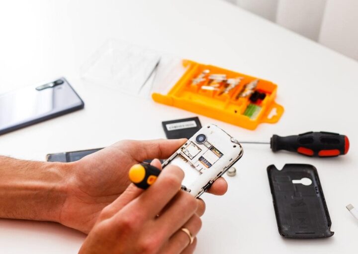 A person holding a cell phone on a table