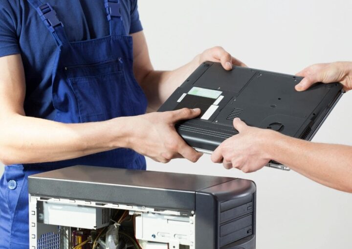 Two businessmen are holding a laptop during a meeting