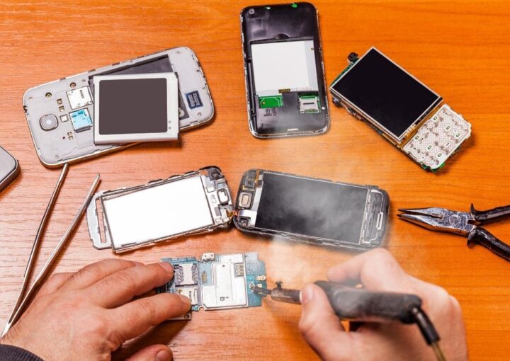 A technician is repairing a damaged smartphone
