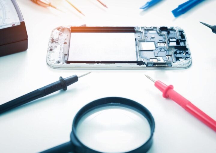 A smartphone resting on a table beside a magnifying glass