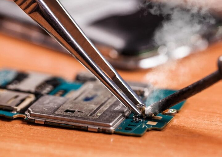 A cell phone being repaired with precision