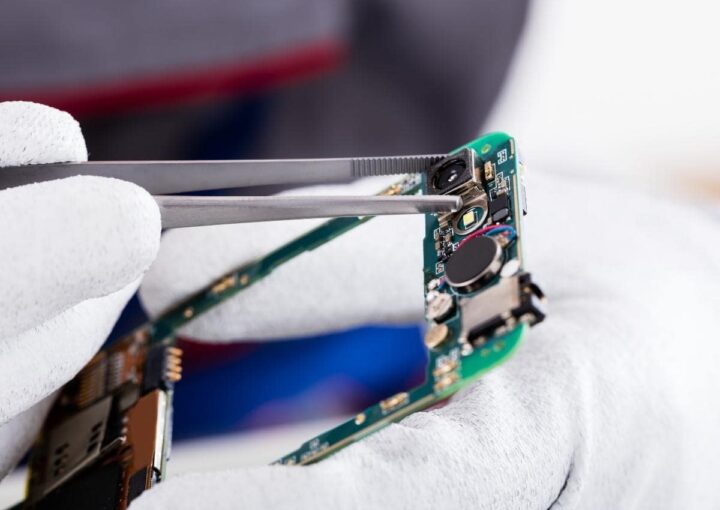 a pair of scissors cutting through a piece of circuit board